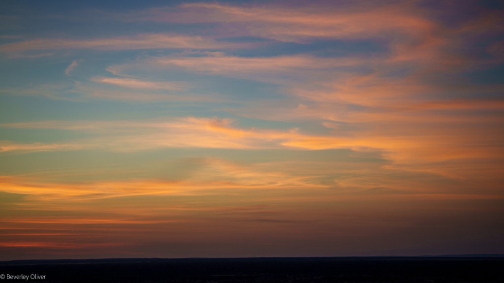 A vibrant sunset sky with soft pastel colors, including shades of orange, pink, and blue, blending seamlessly.